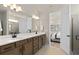 Double vanity bathroom with a large mirror and shower at 7345 Ivy Tendril Ave, Orlando, FL 32829