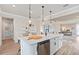 Open concept kitchen with white cabinets, quartz countertops and island at 7345 Ivy Tendril Ave, Orlando, FL 32829