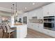 White kitchen with stainless steel appliances and a large island at 7345 Ivy Tendril Ave, Orlando, FL 32829