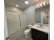 Modern bathroom features a shower-tub combo, dark vanity, and a bright, well-lit mirror at 8066 Glenlloyd Ave, Winter Garden, FL 34787