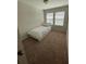 Bedroom featuring carpet flooring, a twin bed, and natural light from two windows at 8066 Glenlloyd Ave, Winter Garden, FL 34787