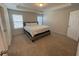 Sunlit bedroom features a bed, carpet floors, two windows with blinds and a tray ceiling at 8066 Glenlloyd Ave, Winter Garden, FL 34787