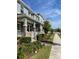 Inviting townhomes with brick accents, porches, and lush landscaping, offering a welcoming curb appeal on a sunny day at 8066 Glenlloyd Ave, Winter Garden, FL 34787