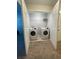 A convenient laundry room with a washer, dryer, shelving, and a carpeted floor at 8066 Glenlloyd Ave, Winter Garden, FL 34787
