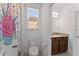 Clean and bright bathroom featuring a toilet, vanity with granite countertop, and patterned shower curtain at 9573 Meadow Hunt Way, Winter Garden, FL 34787