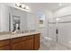 Bathroom with a granite countertop, a large mirror, a toilet, and a glass-enclosed shower at 9573 Meadow Hunt Way, Winter Garden, FL 34787