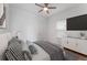 Modern bedroom featuring a ceiling fan, mounted television, and contemporary decor at 9573 Meadow Hunt Way, Winter Garden, FL 34787