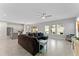 Open-concept living room features a ceiling fan and opens up to the kitchen and dining area at 9573 Meadow Hunt Way, Winter Garden, FL 34787