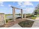 Scenic view of a lake with a charming stone-columned swing providing a tranquil spot to relax and enjoy nature at 9573 Meadow Hunt Way, Winter Garden, FL 34787