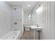 Updated bathroom with marble tile shower, pedestal sink, and wood-look floors at 1021 Flagler Ave, Edgewater, FL 32132
