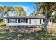 Charming ranch-style home with white exterior, black accents, and landscaped yard at 1021 Flagler Ave, Edgewater, FL 32132