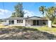 White single story house with screened porch and grassy yard at 1021 Flagler Ave, Edgewater, FL 32132