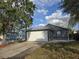 Charming home with a two-car garage, metal roof, and lush green lawn at 1057 Inkberry Ct, Orlando, FL 32811