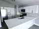 Modern kitchen featuring white cabinets, stainless steel appliances, and a large island with a sink and gray backsplash at 1057 Inkberry Ct, Orlando, FL 32811