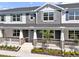 Charming townhome with stone accents, light blue shutters, and a covered front porch with white railings at 1317 Coral Bean Ln, Winter Springs, FL 32708