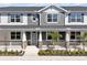 Charming townhome featuring stone accents, blue shutters and a covered porch with white railings at 1317 Coral Bean Ln, Winter Springs, FL 32708