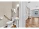 Well-lit half bathroom featuring a pedestal sink, toilet, and accessibility features at 1331 Common Way Rd, Orlando, FL 32814