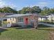 Tan mid-century home with a carport and a spacious yard at 1514 Doreen Ave, Ocoee, FL 34761