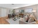 Living room with hardwood floors, mid-century modern furniture, and large windows at 1514 Doreen Ave, Ocoee, FL 34761
