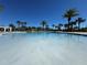 Inviting community pool surrounded by palm trees and lounge chairs on a sunny day at 15547 Hamlin Blossom Ave, Winter Garden, FL 34787