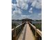 Picturesque covered dock with wood railing and seating, overlooking the tranquil lake at 15547 Hamlin Blossom Ave, Winter Garden, FL 34787