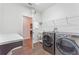 Well-equipped laundry room with modern washer, dryer, utility sink, and counter space at 15547 Hamlin Blossom Ave, Winter Garden, FL 34787