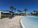 Lounge chairs and umbrellas beside a community pool area surrounded by palm trees at 15547 Hamlin Blossom Ave, Winter Garden, FL 34787