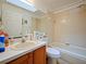 Well-lit bathroom featuring a vanity, a toilet, and a shower-tub combination at 1614 Stanbury Dr, Orlando, FL 32818