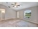 Inviting living room with neutral carpet, large window, and a ceiling fan for year-round comfort at 17008 Sw 32Nd Ter, Ocala, FL 34473