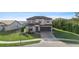 Two-story house with a brown roof, gray siding, and a brick paved driveway at 175 Claffey Ct, Haines City, FL 33844