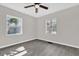 Well-lit bedroom with two windows and ceiling fan at 204 Louis St, Leesburg, FL 34748