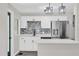 Modern kitchen with white cabinets, stainless steel appliances, and gray backsplash at 204 Louis St, Leesburg, FL 34748