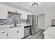 Modern kitchen with stainless steel appliances and white cabinets at 204 Louis St, Leesburg, FL 34748