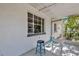 Cozy porch with two blue stools and white table at 204 Louis St, Leesburg, FL 34748