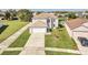 Wide aerial shot of a gray house with a large driveway and beautiful green lawn at 2120 Marisol Loop, Kissimmee, FL 34743