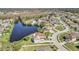 An aerial view of a residential community featuring homes surrounding a scenic lake and tree lined streets at 2120 Marisol Loop, Kissimmee, FL 34743