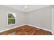 Bedroom boasts a ceiling fan, hardwood floors, natural light, and neutral decor at 2120 Marisol Loop, Kissimmee, FL 34743