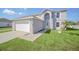 Attractive two-story home with a manicured lawn, light gray paint, and a two-car garage at 2120 Marisol Loop, Kissimmee, FL 34743