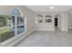 Bright living room with arched windows, tile floors and view to the kitchen at 2120 Marisol Loop, Kissimmee, FL 34743
