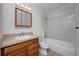 Cozy bathroom with white tiled shower and tub, wood vanity with sink, and medicine cabinet at 230 Moree Loop # 4, Winter Springs, FL 32708