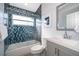Updated bathroom features stylish blue mosaic tiles and a glass shower door at 2551 Bear Creek Ct, Kissimmee, FL 34747