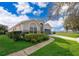 Well-manicured lawn leads to a home featuring a blue garage door and arched entryway at 2551 Bear Creek Ct, Kissimmee, FL 34747