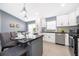 Island with seating highlights this kitchen's white cabinets, stainless steel appliances, and bright design at 2551 Bear Creek Ct, Kissimmee, FL 34747