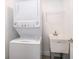 Compact laundry area with stacked washer/dryer unit and a sink, designed for maximum space efficiency at 2551 Bear Creek Ct, Kissimmee, FL 34747