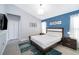 Stylish main bedroom features a calming blue accent wall and neutral furnishings at 2551 Bear Creek Ct, Kissimmee, FL 34747