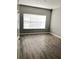 Bright bedroom with wood-look floors and large window with blinds at 2586 Grand Central Pkwy # 1, Orlando, FL 32839