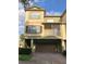 Front view of a three-story townhome with a brown garage door and balcony at 2586 Grand Central Pkwy # 1, Orlando, FL 32839