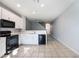 Bright kitchen featuring modern appliances, white cabinetry, and seamless flow into the living area at 2605 Andros Ln, Kissimmee, FL 34747