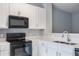 Modern kitchen with white cabinets and black appliances at 2605 Andros Ln, Kissimmee, FL 34747