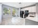 Bright eat-in kitchen featuring white cabinetry, black appliances, and an adjacent outdoor area at 2605 Andros Ln, Kissimmee, FL 34747